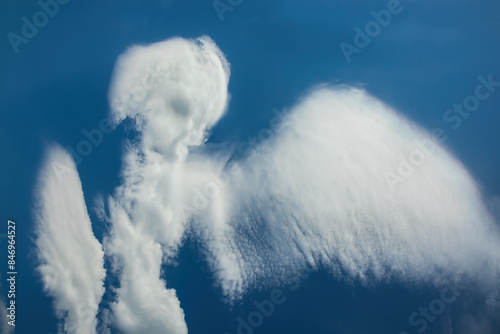 Cloud in the shape of an angel. Daytime blue sky with natural clouds. Pareidolia