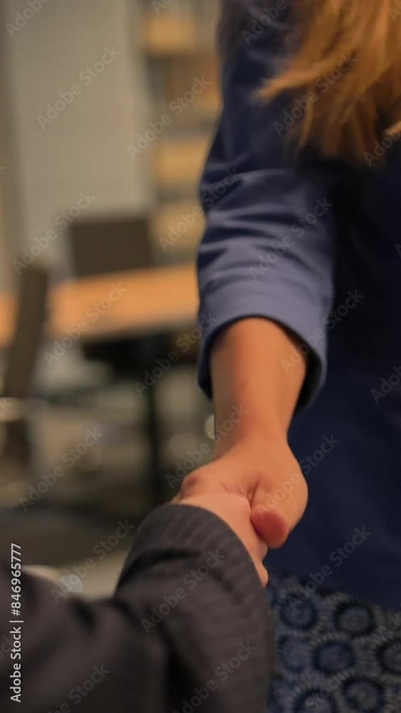 Two Happy young businesswomen shaking hands inside of modern business coworking office. Hands close up shot in slow motion. Vertical shot. Two Happy young businesswomen shaking hands inside of modern business coworking office. Hands close up shot in slow motion. Vertical shot.