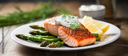 Close-up view of a plate of food featuring asparagus spears and a lemon, isolated on a white wooden table. with copy space image. Place for adding text or design