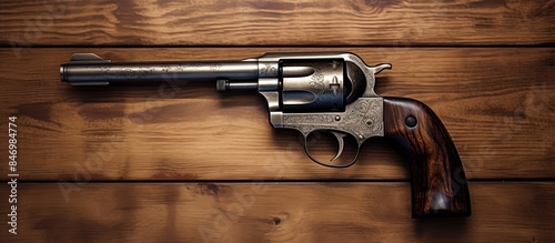 A handgun with a short barrel and stock, suggestive of a revolver, placed on a textured wooden tabletop. with copy space image. Place for adding text or design photo