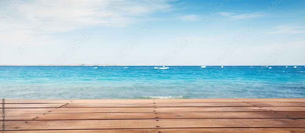 Fototapeta premium Wooden deck overlooking the ocean, with a view of boats in the distance. with copy space image. Place for adding text or design