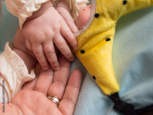 Mother holding newborn hand, concept of family tenderness