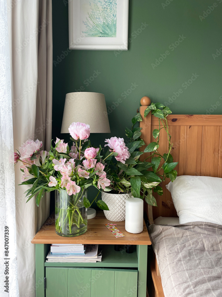 A bedroom with a green wall and a bed table