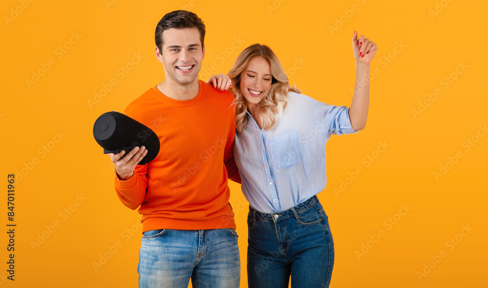 Obraz premium attractive stylish young couple holding wireless speaker