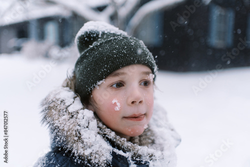 happy boy in winter clothing spending day in snow photo