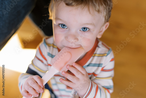 cute toddler chewing on a spatula at home photo