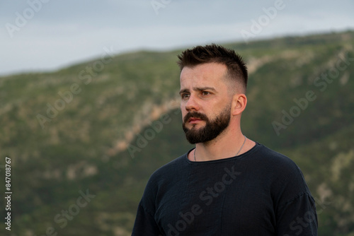 A handsome young Albanian man looking at a landscape of Kanina in Vlore, southern Albania. 