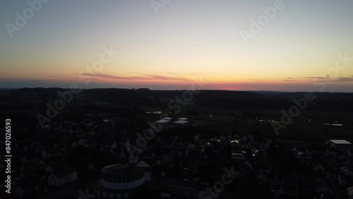 Drohnenaufnahme von hohem Kirchturm von Diedorf bei Sonnenuntergang