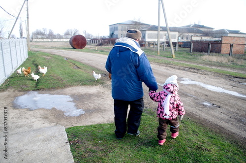 grandfather and little granddaughter are walking  photo