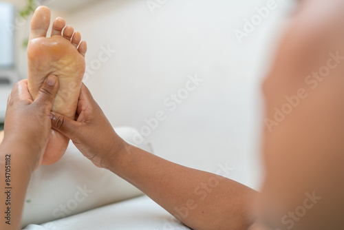 Foto Latin female masseur giving reflexology treatment to a woman