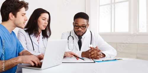 Medical Team Discussing Reports, Using Laptop in Meeting Room