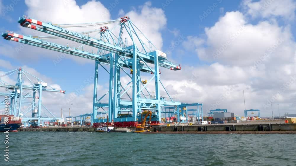 Rotterdam, The Netherlands - April 24, 2024: Large gantry cranes and container ship - port of Rotterdam - Maasvlakte. The Maasvlakte is a massive westward extension of the Europoort port Rotterdam, The Netherlands - April 24, 2024: Large gantry cranes and container ship - port of Rotterdam - Maasvlakte. The Maasvlakte is a massive westward extension of the Europoort port