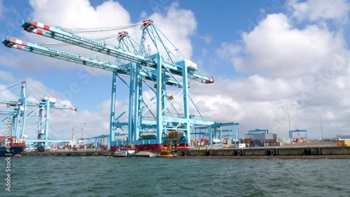 Rotterdam, The Netherlands - April 24, 2024: Large gantry cranes and container ship - port of Rotterdam - Maasvlakte. The Maasvlakte is a massive westward extension of the Europoort port photo