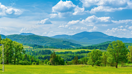 Fototapeta Naklejka Na Ścianę i Meble -  picturesque landscape of green hills and blue mountains under bright sky with fluffy clouds