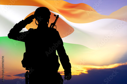Silhouette of a soldier against the sunset with Niger flag. National Holidays concept