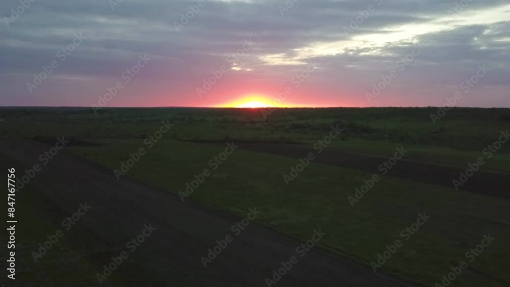 Enjoy a breathtaking view of the gorgeous sunset over expansive green fields and winding roads Enjoy a breathtaking view of the gorgeous sunset over expansive green fields and winding roads