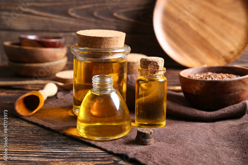 Bottles of flax oil and seeds on wooden background