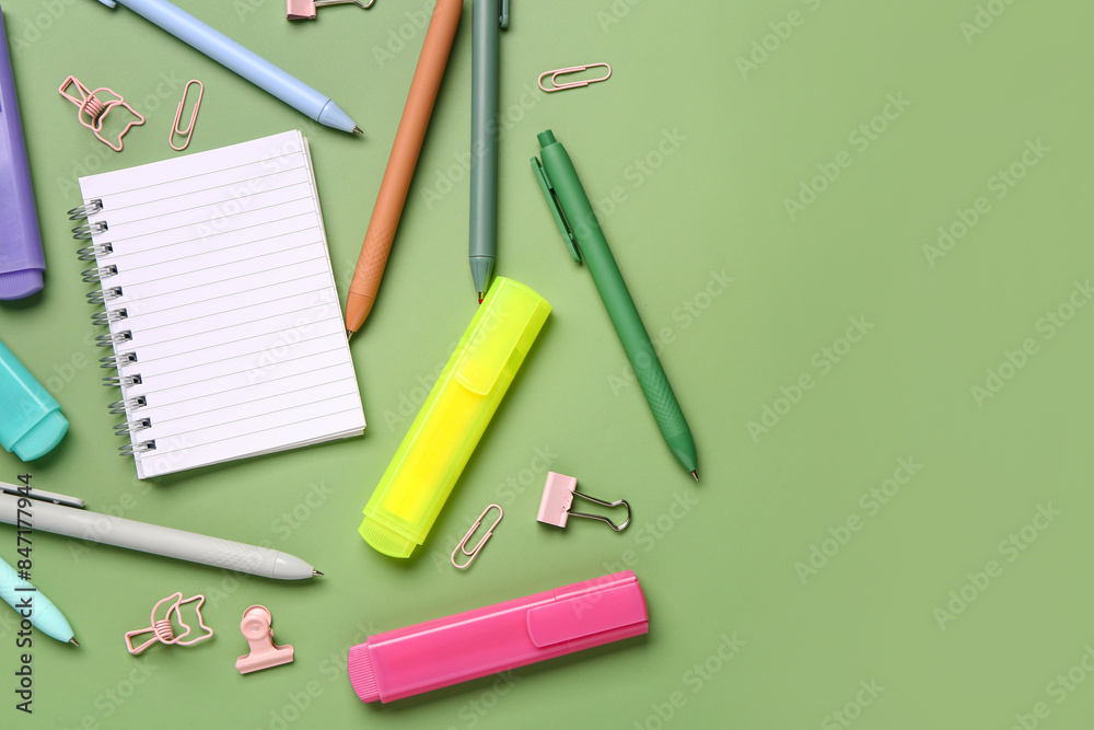 Blank notebook with school stationery on green background Blank notebook with school stationery on green background