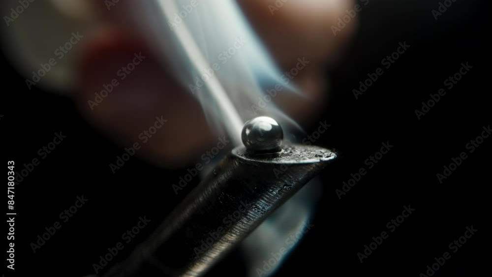 Solder Melting on the Overheated and Burned Soldering Iron Tip, Forming a Smooth Sphere without Adhering, Macro. Solder Melting on the Overheated and Burned Soldering Iron Tip, Forming a Smooth Sphere without Adhering, Macro.