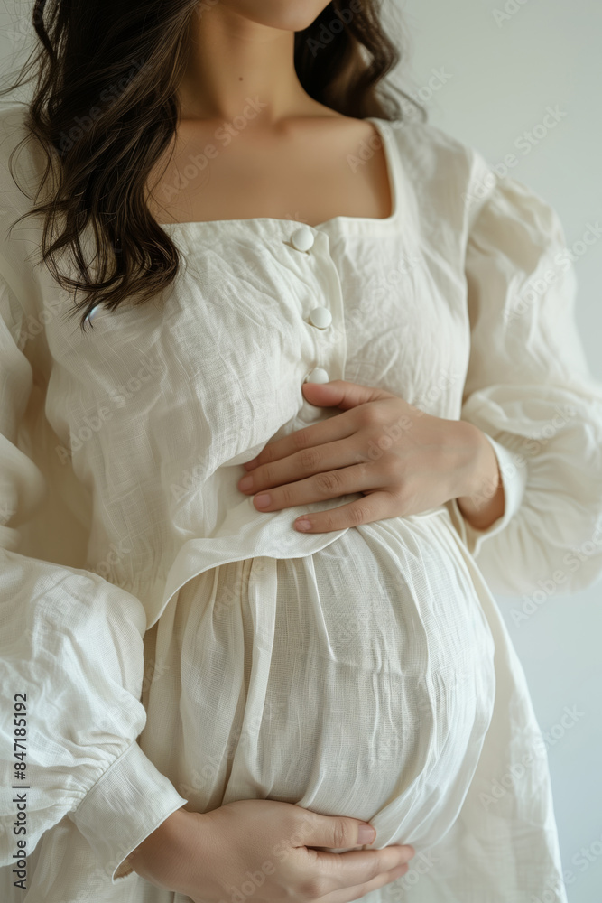 A pregnant woman waiting for her baby lovingly cuddles her belly A pregnant woman waiting for her baby lovingly cuddles her belly