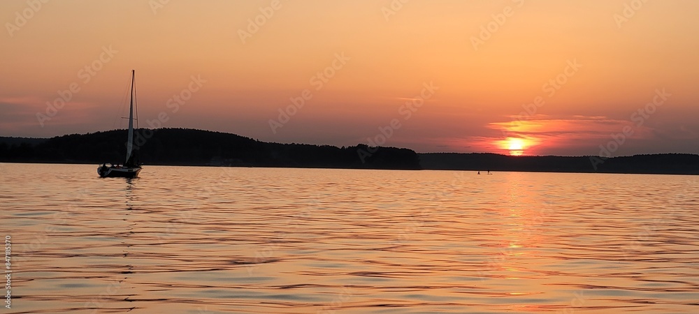 Yacht on the lake at an orange sunset. Yacht on the lake at an orange sunset.