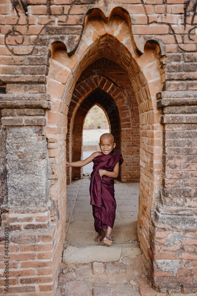 Young monk smiling in temple archway Young monk smiling in temple archway