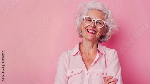 A woman with glasses and a pink shirt smiling