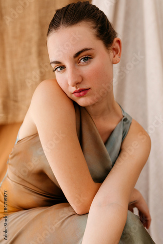 Trendy model squatting and looking at camera