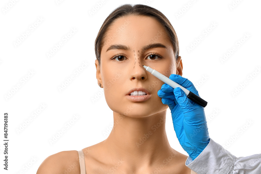 Doctor in protective gloves drawing marks on woman's nose for plastic surgery against white background Doctor in protective gloves drawing marks on woman's nose for plastic surgery against white background