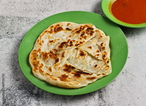 plain pratam porata or paratha with chilli sauce served in dish isolated on grey background side view of singapore food photo