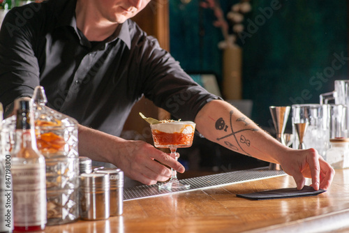 Bartender prepares cocktail at the bar counter photo