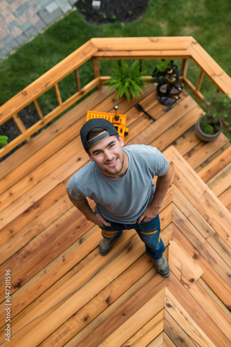 Construction worker smiling proud after building new wooden deck