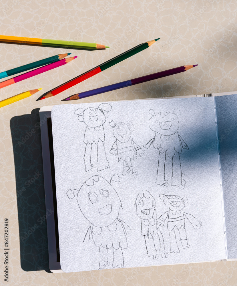 Child's Sketchbook with Colorful Pencils on Table Child's Sketchbook with Colorful Pencils on Table
