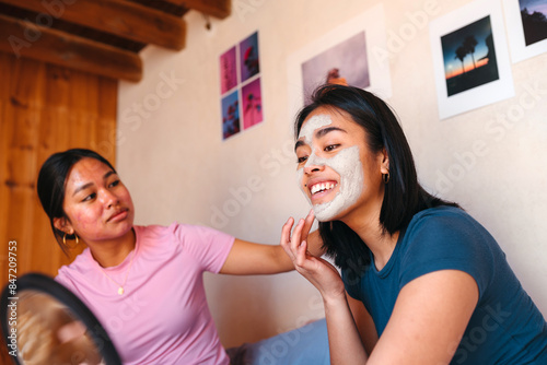 Two best friends doing their skincare routine together photo