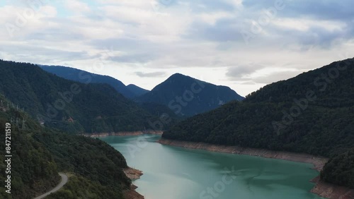 Aerial view of the turquoise reservoir. Beautiful view of the road among the mountains.  View of the river, road, clouds. 4k video. 