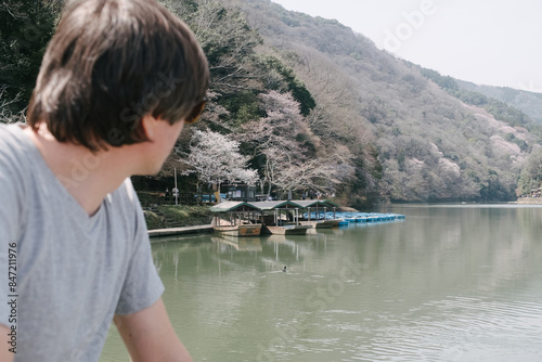 A man looking at Katsuta lake in Arashiyama photo