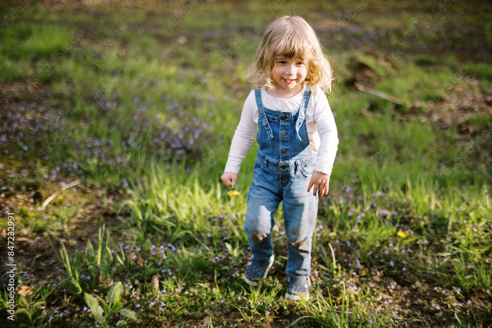 toddler girl outdoors in backyard garden in spring toddler girl outdoors in backyard garden in spring