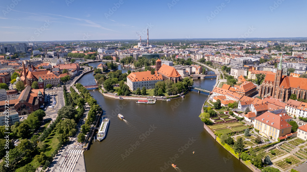 A drone view of Wyspa Piasek and Most Tumski in Wrocław reveals their historic charm and scenic beauty.