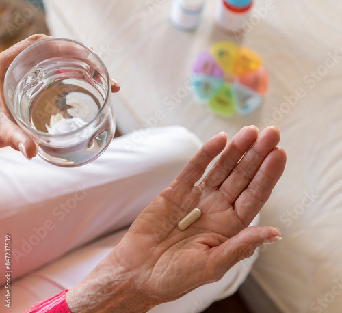 Close up supplement pill in hand of Senior 