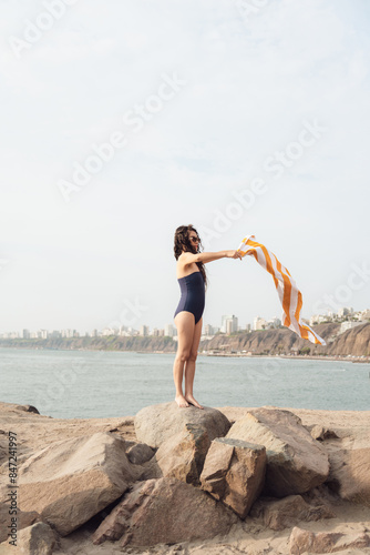 Woman Shaking Sand Off Towel at the Beach