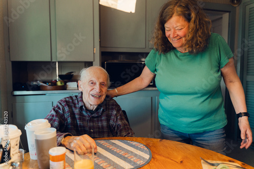 portrait of happy elderly man  with his daughter   in his kitchen   photo