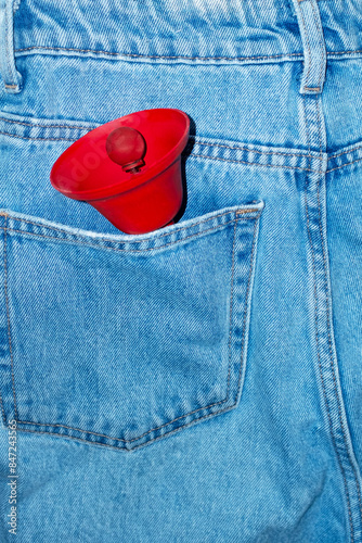 Classic blue denim jeans and red ringing bell in pocket and flashlight