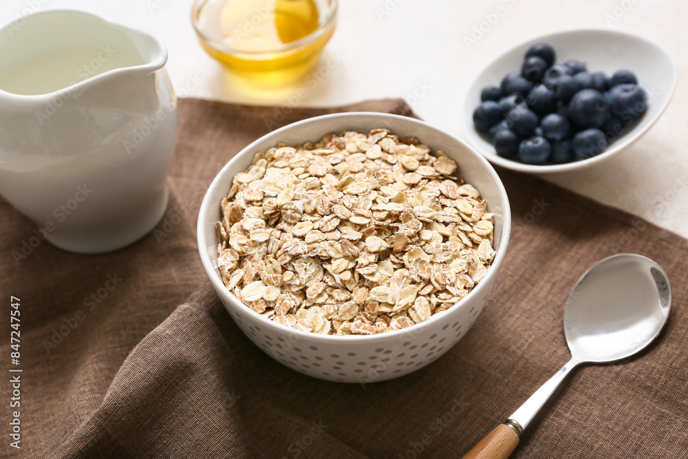 Napkin, bowl with raw oatmeal and berries on light background, closeup Napkin, bowl with raw oatmeal and berries on light background, closeup
