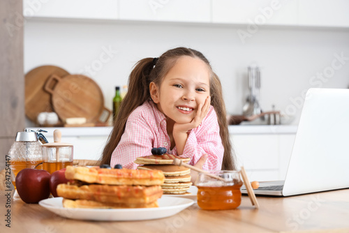 Cute little girl with lapto...