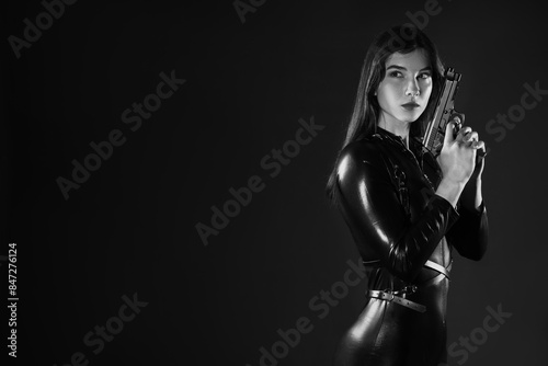 Female spy with gun on dark...
