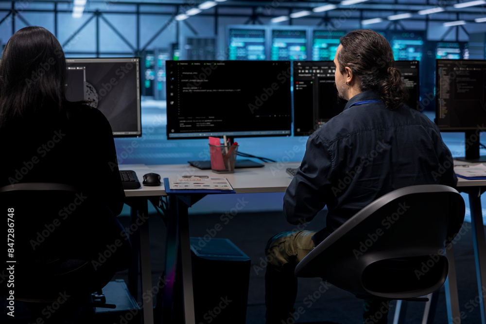 IT professionals in server hub establishment ensuring data remains shielded from potential threats. Teamworking colleagues safeguarding data center against unauthorized access IT professionals in server hub establishment ensuring data remains shielded from potential threats. Teamworking colleagues safeguarding data center against unauthorized access