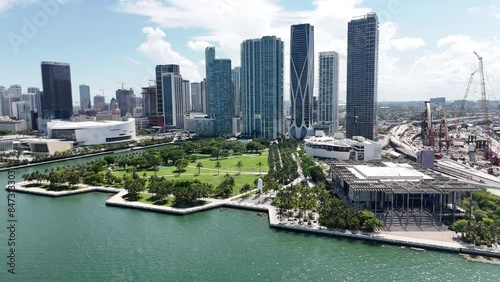epic wide shot of downtown miami from a drone showing a park, buildings, museums, and arena in south florida during sunny day