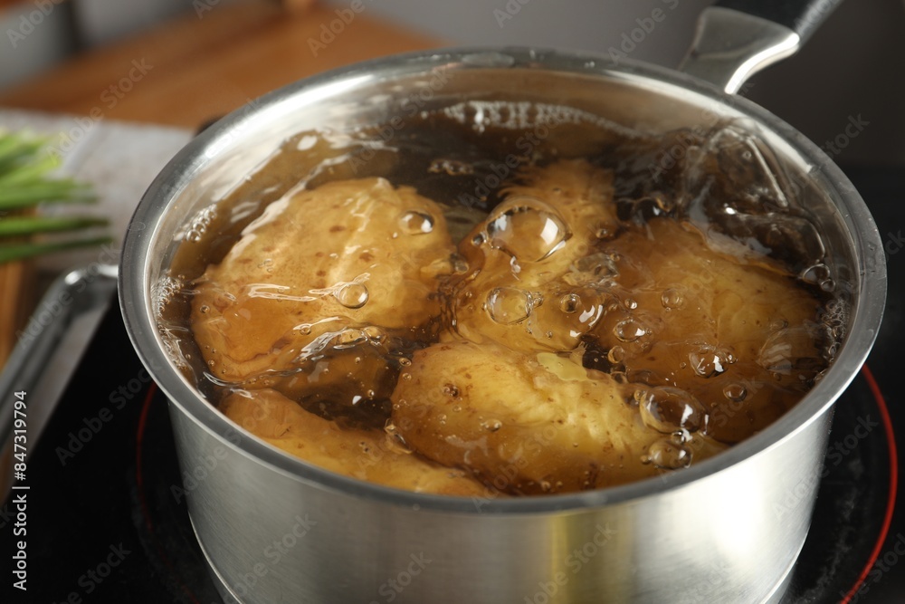 Boiling potatoes in saucepan on stove, closeup Boiling potatoes in saucepan on stove, closeup