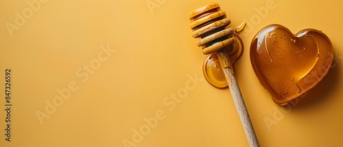 Honey dipper with heart-shaped liquid honey isolated on orange background with copy space