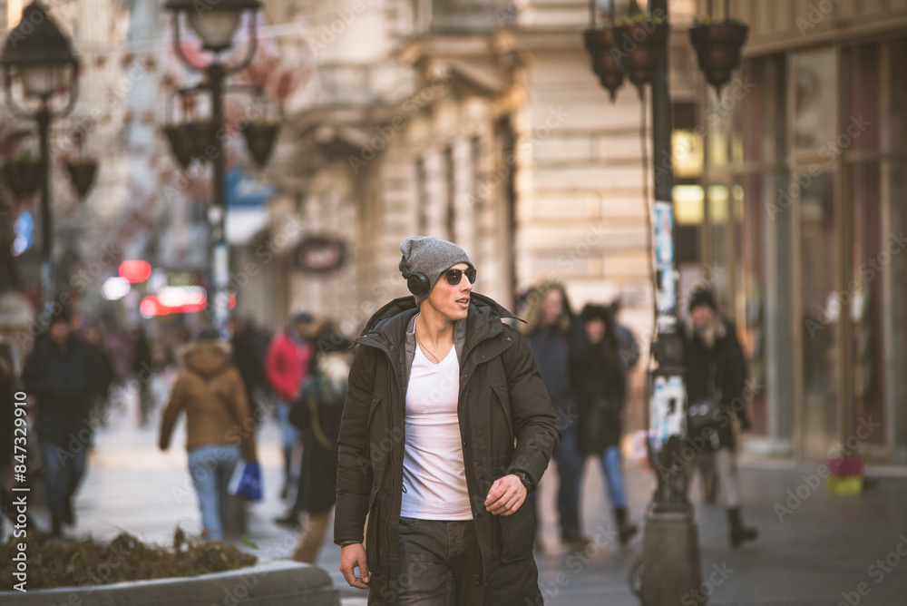 Young Man in the Winter City Streets with Headphones